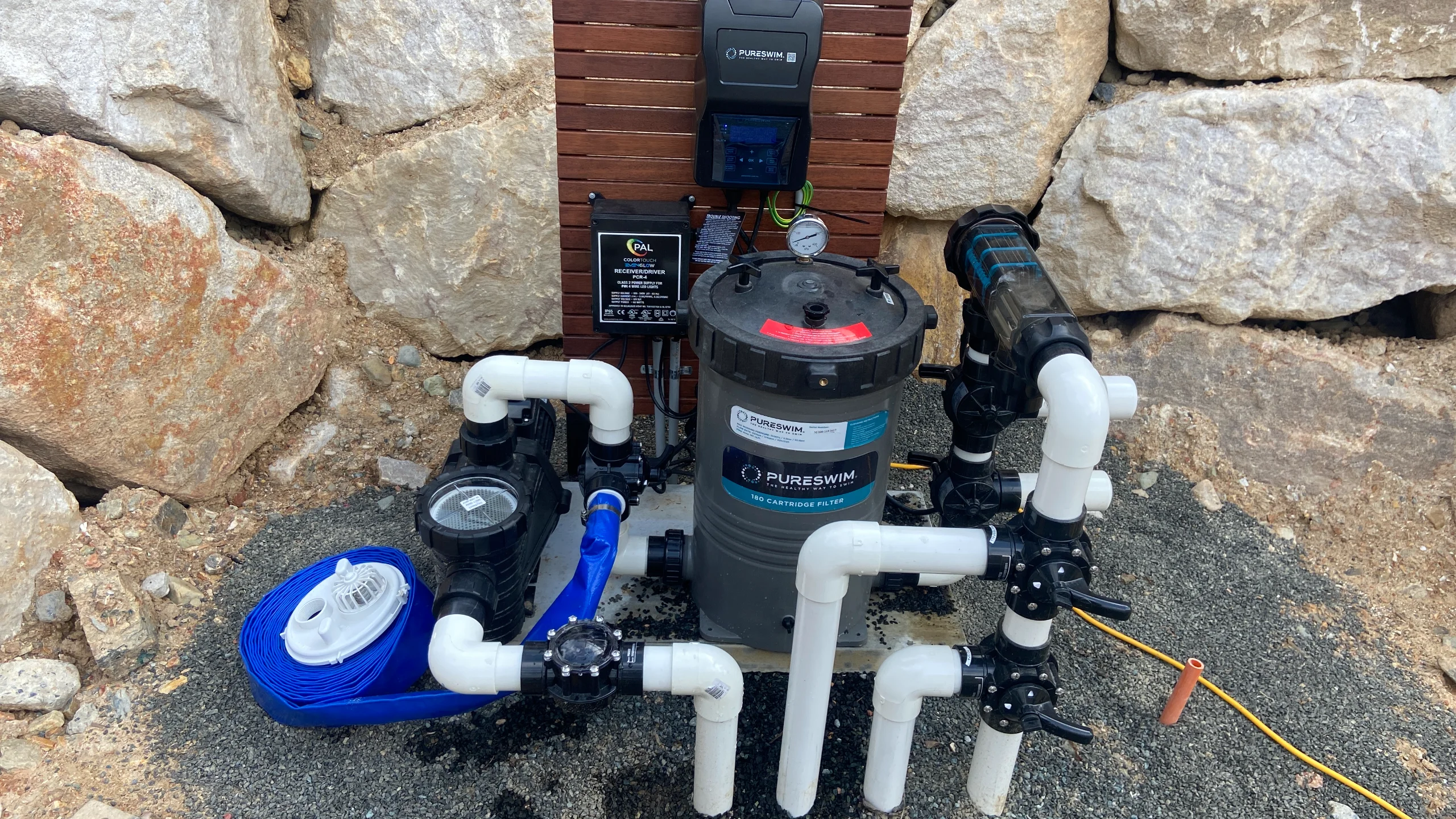 PureSwim cartridge filter and pump with PVC valves and control panel set against a stone wall